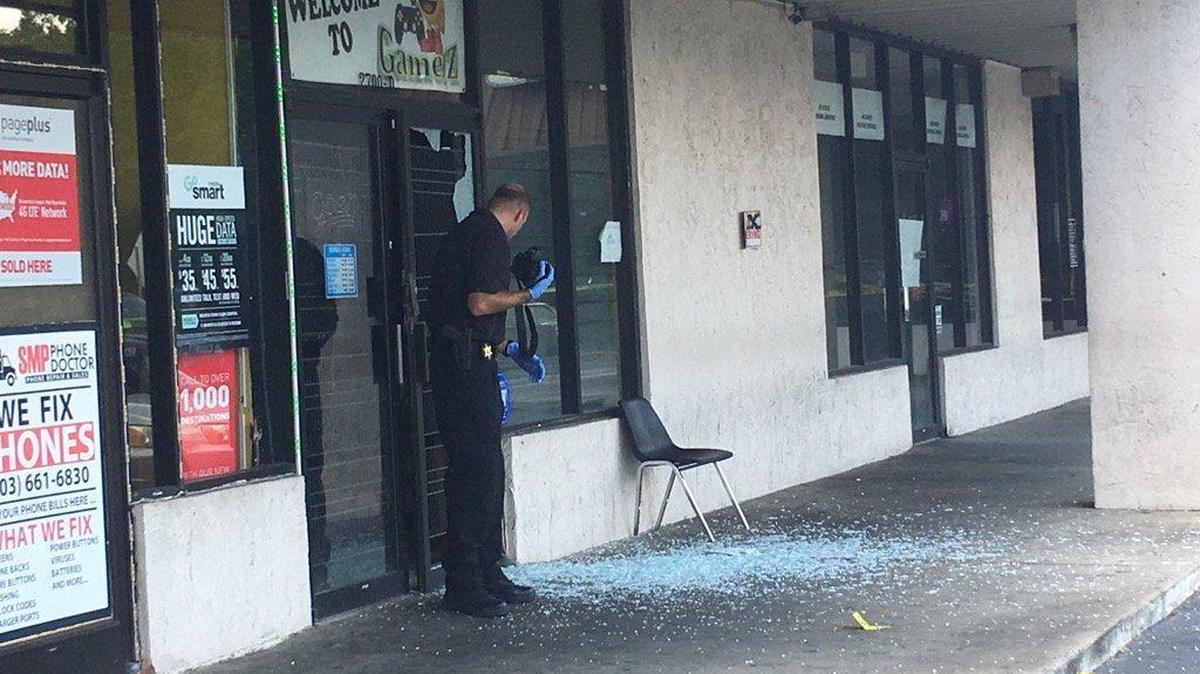 A gun battle between a business owner and a robber shattered the door of the business on Broad River Road.
