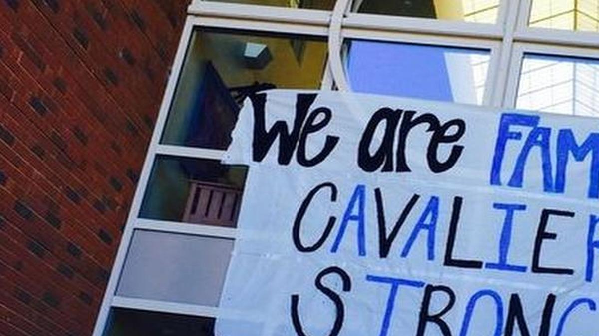 
Christ Church Episcopal School seniors look at a banner they hung above the school entrance in response to a racist photo created by a student.
