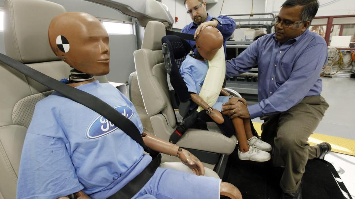 In this photo made Monday, Nov. 2, 2009, Edward DeSmet, left, technical specialist, Global Seatbelts, Body Engineering and Srini Sundararajan, right, technical leader, Passive Safety, Research and Advanced Engineering adjust a crash dummy with an inflatable seat belt on a demonstrator at Ford Motor Co. in Dearborn, Mich. Ford Motor Co. plans to introduce seat belt-mounted air bags in the back seat of the 2011 Ford Explorer sport utility vehicle, which will hit the market next fall. Ford says it's the first automaker to mass produce the technology. (AP Photo/Paul Sancya)
