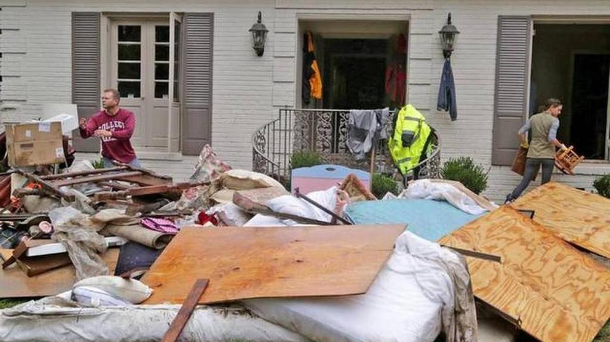 Alex McLaughlin and Marianna Cartin go through water-damaged items from Marianna and Walt Cartin’s home after the October floods.