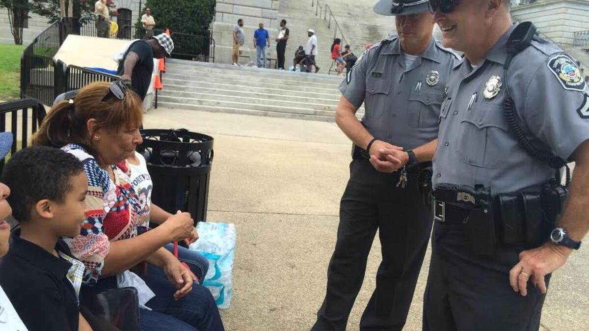 Two state Transport Police officers talk and laugh with Senorita Sullivan, mother of event organizer Chris Sullivan, and 7-year-old Cameron Sullivan, Chris Sullivan’s son.