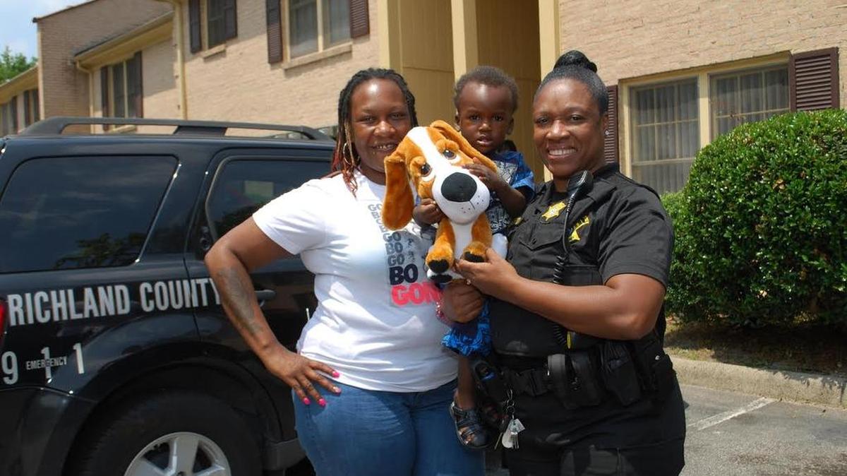 Vera Anderson (left) and her son stand with Richland County deputy Darlene Crawford, who saved the boy from choking during a graduation ceremony.