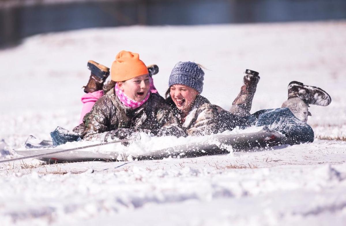 Savannah Gerald and Meredith Harrelson, both age 11, were pulled on an old car hood through the snow by a 4-wheeler driven by Chuck Harrelson at his farm outside Aynor on Thursday. While much of the Grand Strand missed the heaviest snowfall from Winter Storm Grayson, residents of Aynor woke up to over three inches of snow on Thursday. Jan. 4, 2018.