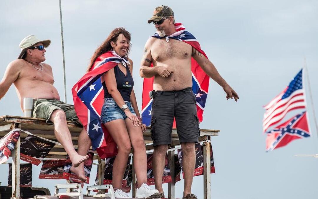 
Herman Ray (LEFT), Misty Allbright and Lance Kenyon tailgate from a vehicle rooftop Saturday afternoon at the Southern 500 in Darlington, South Carolina. Following the June massacre in Charleston and the removal of the Confederate battle flag from the statehouse grounds the traditional symbol for southern race fans continues to face scrutiny. 9/6/15 9/6/15 
