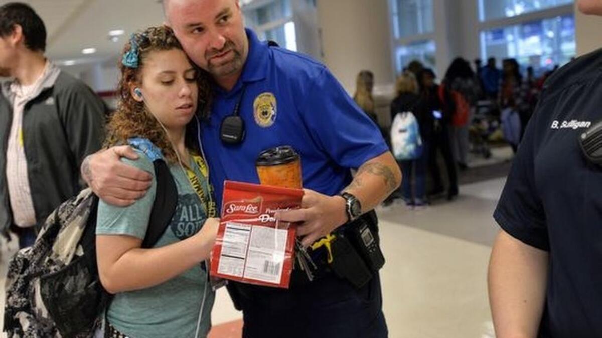 A student gives Tony Koutsos, a school resource officer at Mauldin High School, a hug before classes start on Nov. 6, 2015. (Photo: MYKAL McELDOWNEY/Staff)