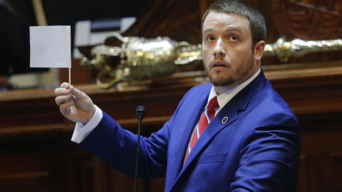 Rep. Christopher Corley, R- Aiken, shows his frustration by waving a white flag of surrender during debate over a Senate bill calling for the Confederate flag to be removed from the Capitol grounds Wednesday, July 8, in Columbia.
