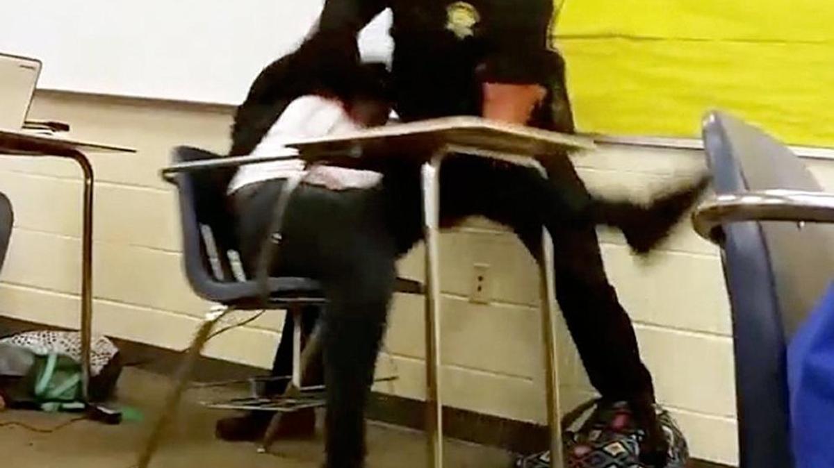In this Monday, Oct, 26, 2015 photo made from video taken by a Spring Valley High School student, Senior Deputy Ben Fields tries to forcibly remove a student who refused to leave her high school math class, in Columbia.