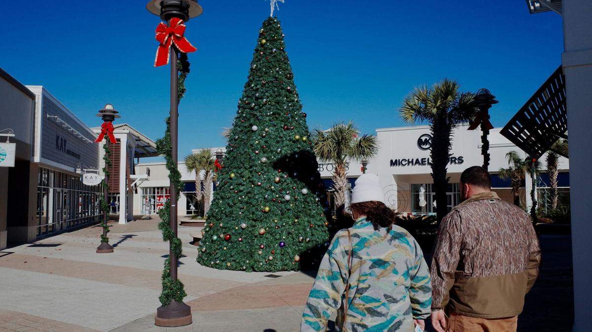 Shoppers brave gusty winds and falling temperatures to fulfill their holiday wish lists at Tanger Outlets near Myrtle Beach, S.C. Dec. 23, 2022.