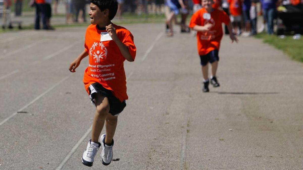 
Special Olympian William Sweda-Chandler looks to the stands as he races to a first-place finish in the 2010 Special Olympics competition at Socastee High School. 
