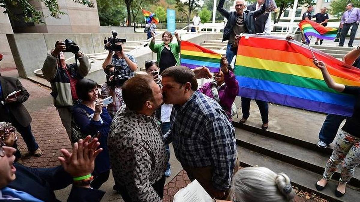 
(L-R) Dr. Jesus Hernandez and Oscar Hull kiss following their marriage ceremony outside the Mecklenburg County and Courts Office building on Monday, October 13, 2014. Monday was the first day that gay couples could marry in Mecklenburg County after a judge's ruling.

