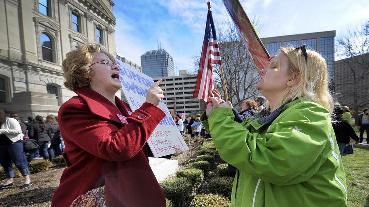 
In this Tuesday, March 8, 2011 file photo, Planned Parenthood supporter Peg Paulson of Carmel, Ind., left, and opponent Heather Pruett of Indianapolis argue during a rally at the Indiana Statehouse on the South Lawn in Indianapolis in response to an Indiana House bill which would end funding to Planned Parenthood because it provides abortions. (AP Photo/The Indianapolis Star, Alan Petersime)

