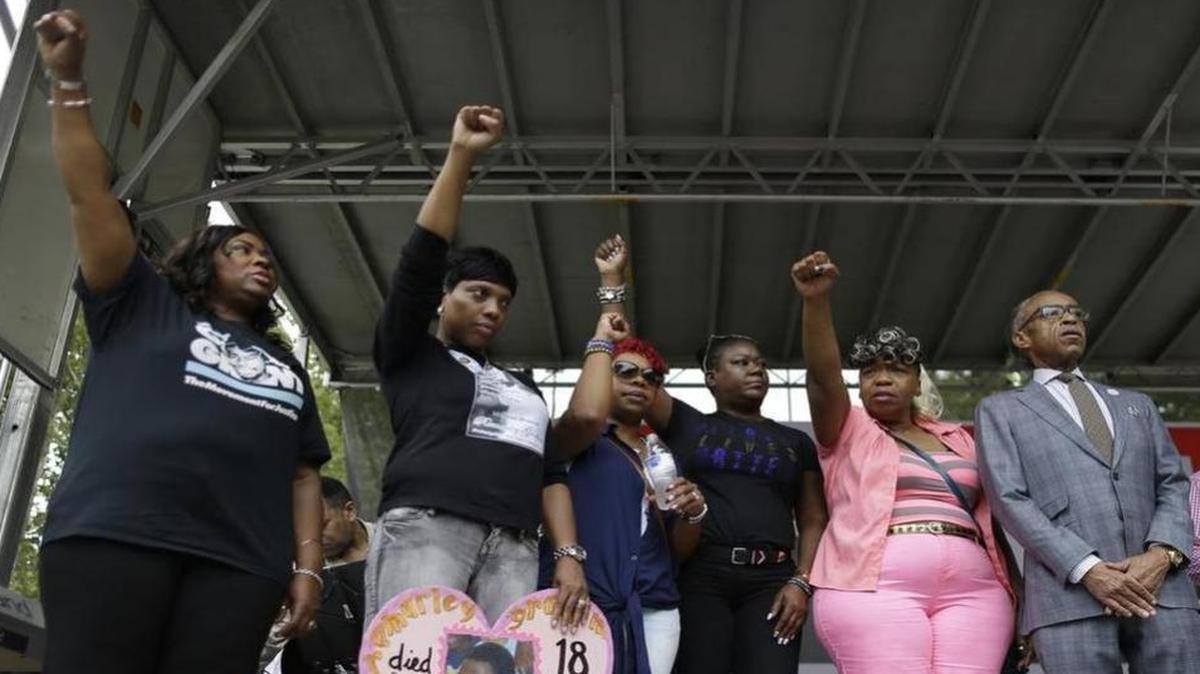 
The Rev. Al Sharpton, right, is joined on stage by shooting victim Oscar Grant’s mother, Wanda Johnson, left; shooting victim Ramarley Graham’s mother, Constance Malcolm, second from left; shooting victim Michael Brown’s mother, Leslie McSpadden, third from left; shooting victim Trayvon Martin’s mother, Sybrina Fulton, third from right; and shooting victim Eric Garner’s mother, Gwen Carr, during a rally in New York on Saturday, July 18, 2015. Several hundred people rallied outside the federal courthouse in Brooklyn to demand action in the fatal chokehold death of Eric Garner by a white police officer. | MARY ALTAFFER AP
