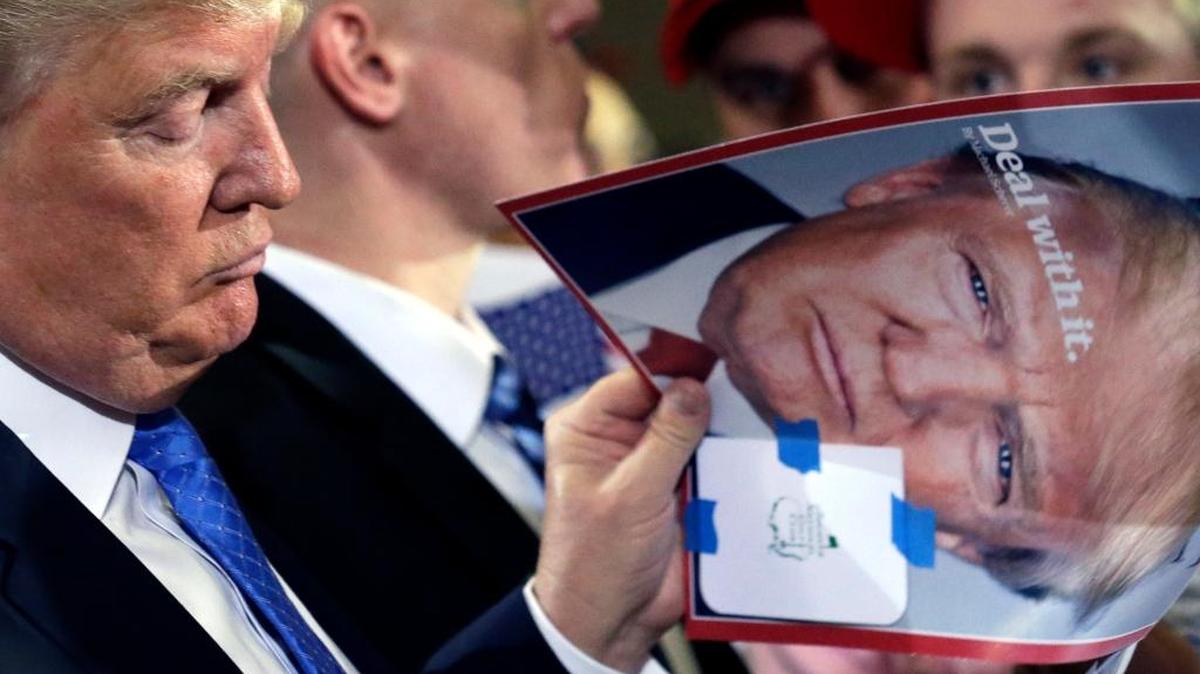Republican presidential candidate Donald Trump talks with his supporters as he checks his photos at a campaign stop Tuesday.