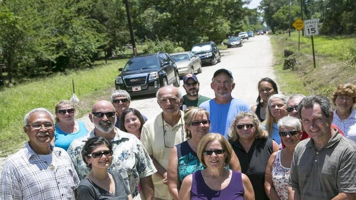 
Felicia Soto (center) calls together members from the community surrounding the S.C. 90 end of International Drive to express their frustration on the lack of progress for paving the thruway. | Jason Lee jlee@thesunnews.com
