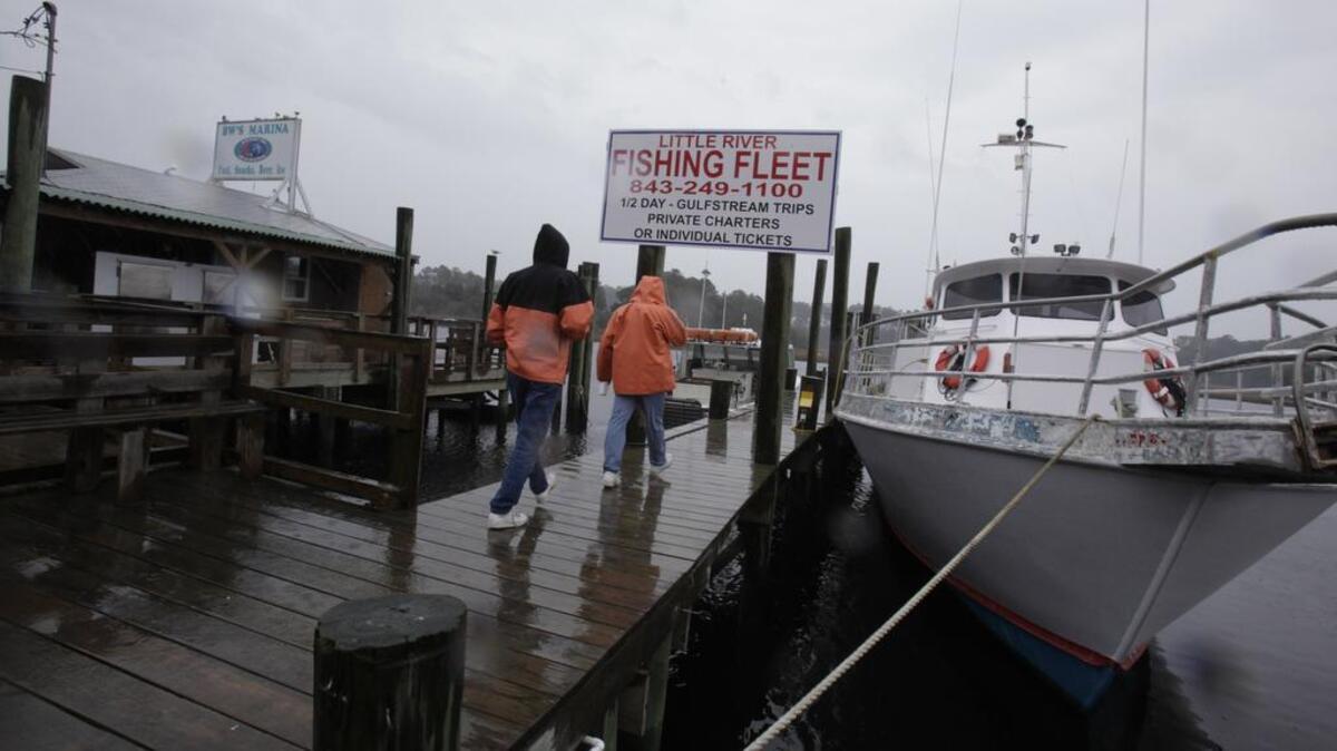 
Commercial and charter fishermen with Little River Fishing Fleet, walk to their boat on the waterfront in Little River in this 2010 file photo.
