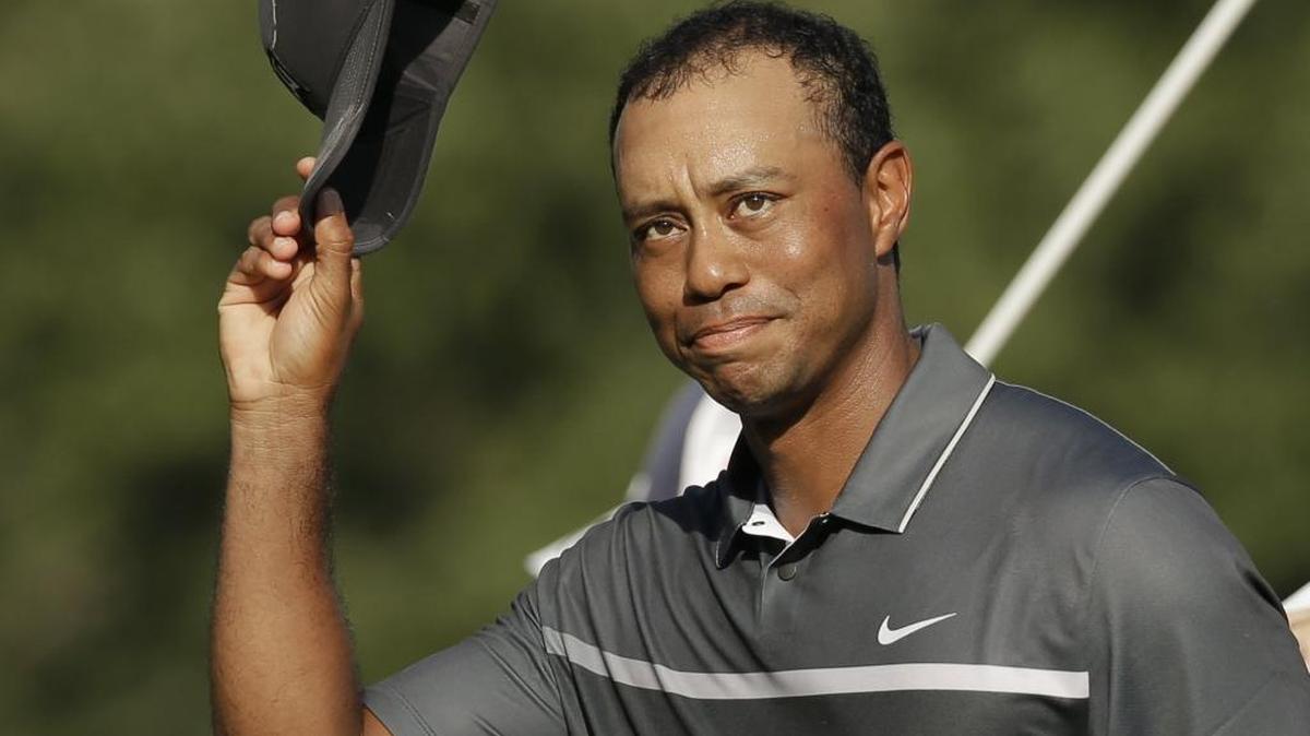 In this Aug. 21, 2015, file photo, Tiger Woods tips his hat to the crowd after finishing his round on the 18th hole during the second round of the Wyndham Championship golf tournament in Greensboro, N.C.