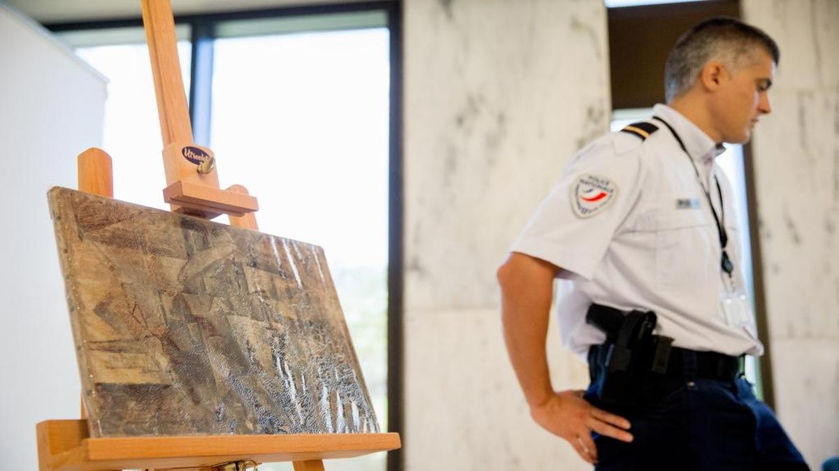 An officer stands guard next to Pablo Picasso’s painting entitled “La Coiffeuse,” Thursday, Aug. 13, 2015, at the French Embassy in Washington. The U.S. Immigration and Customs Enforcement returned the painting, valued at $15 million, stolen in 1998 and was seized in December 2014.