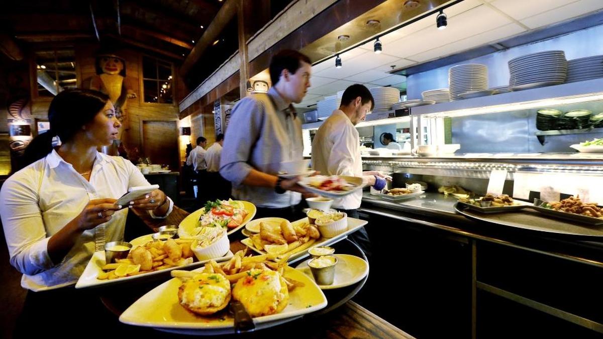 Workers prepare to bring food orders to customers at an Ivar's restaurant in Seattle. After Seattle's new minimum wage law took effect last April 1, Ivar’s Seafood Restaurants announced that it was raising its prices by about 21 percent, eliminating tipping as a routine procedure, and immediately paying all its hourly workers a $15 per hour. They began the new pay rate three years earlier than the law required.