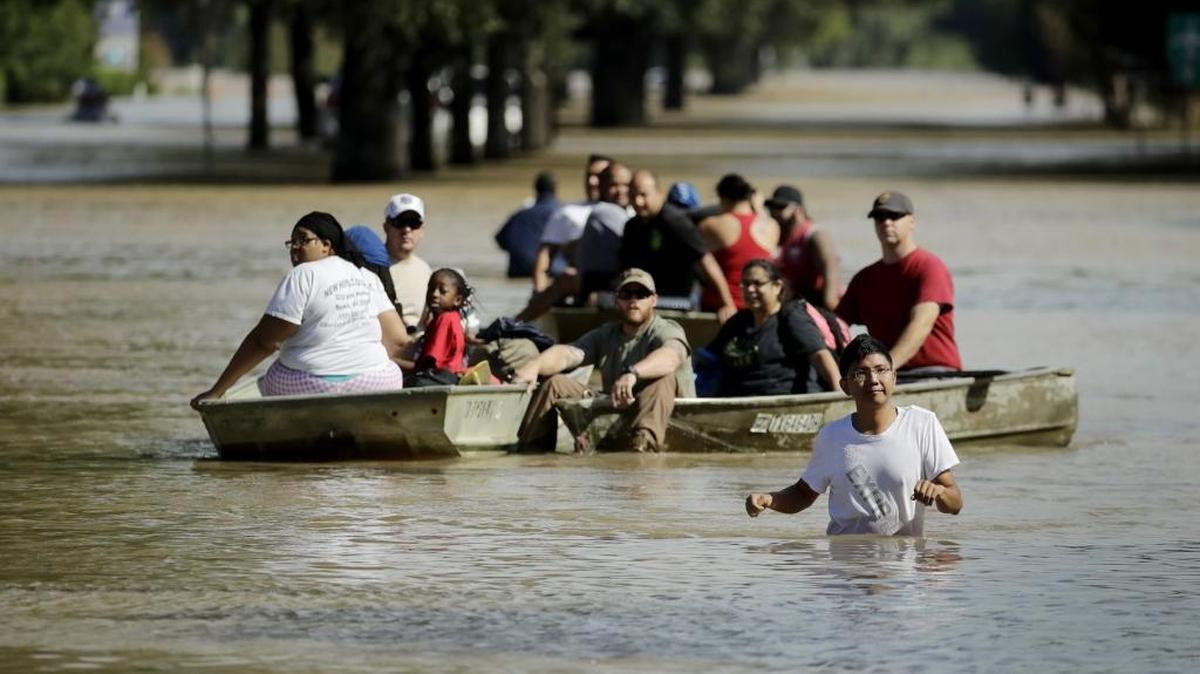 People evacuate a neighborhood inundated after water was released from nearby Addicks Reservoir when it reached capacity due to Tropical Storm Harvey on Wednesday.