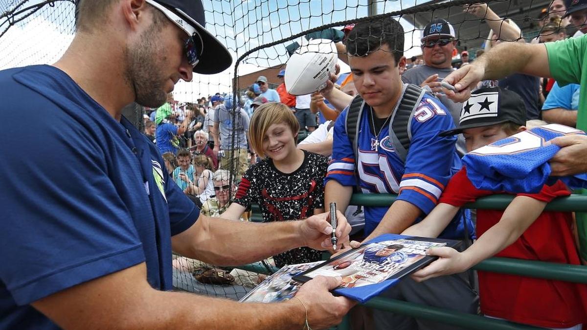 Columbia Fireflies player Tim Tebow signs an autograph before a game against the Hickory Crawdads last month.