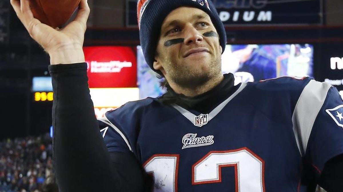 
FILE - In this Jan. 10, 2015, file photo, New England Patriots quarterback Tom Brady holds up the game ball after an NFL divisional playoff football game against the Baltimore Ravens in Foxborough, Mass. 
