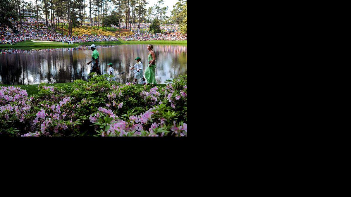
Tiger Woods, left, leads his son Charlie, daughter Sam and partner Lindsey Vonn past the azaleas toward the ninth green during the Par 3 contest on Wednesday, April 8, 2015, at Augusta National Golf Club in Augusta, Ga. 
