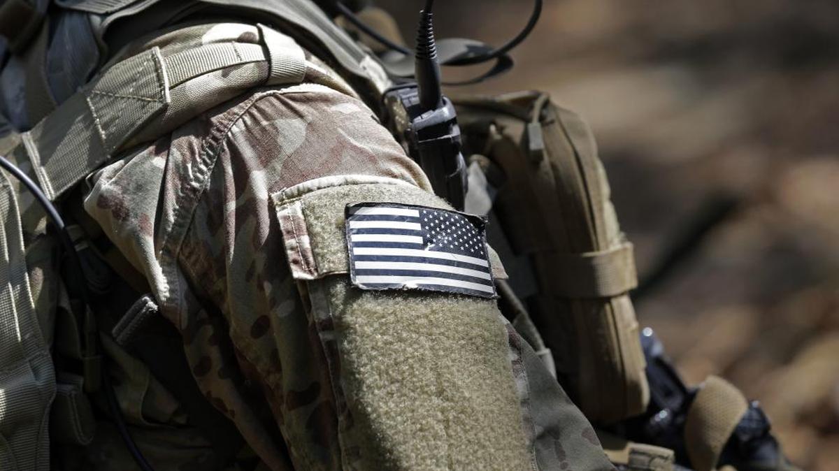 In this photo taken Friday, April 21, 2017 a United States flag patch adorns the uniform of a paratrooper with the 82nd Airborne Division's 3rd Brigade Combat Team during a training exercise at Fort Bragg, N.C. The Army is planning to triple the amount of bonuses it’s paying this year to more than $380 million in a bid to expand its ranks. The money includes new incentives to woo reluctant soldiers to re-enlist.