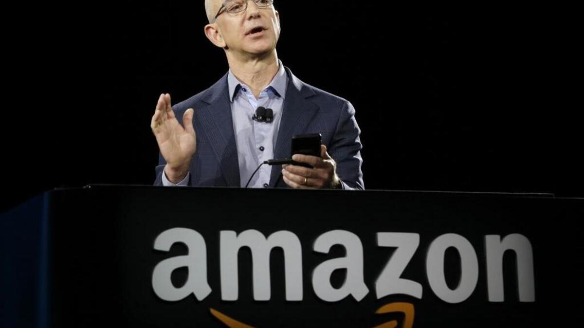 In this Wednesday, June 18, 2014, file photo, Amazon CEO Jeff Bezos demonstrates the new Amazon Fire Phone, in Seattle.