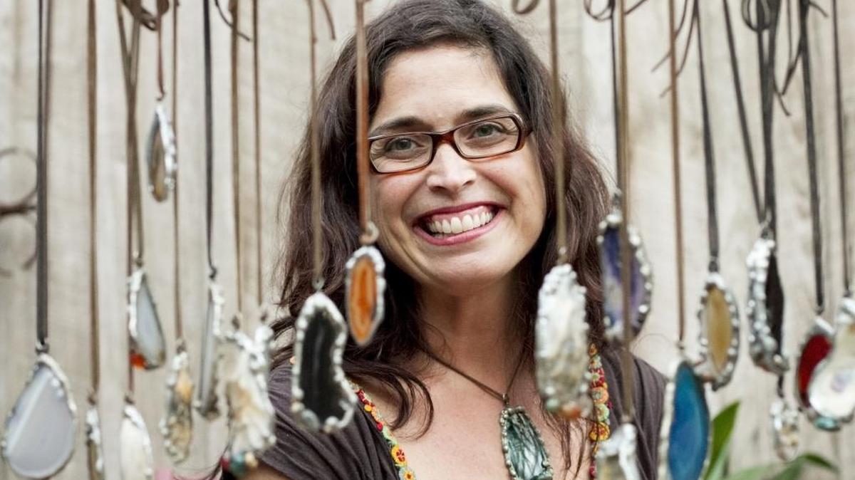 Antonia Moore uses a soldering iron to create unique pieces of jewelry from collected shells, agate, and other natural stones in her home studio in Pawleys Island.