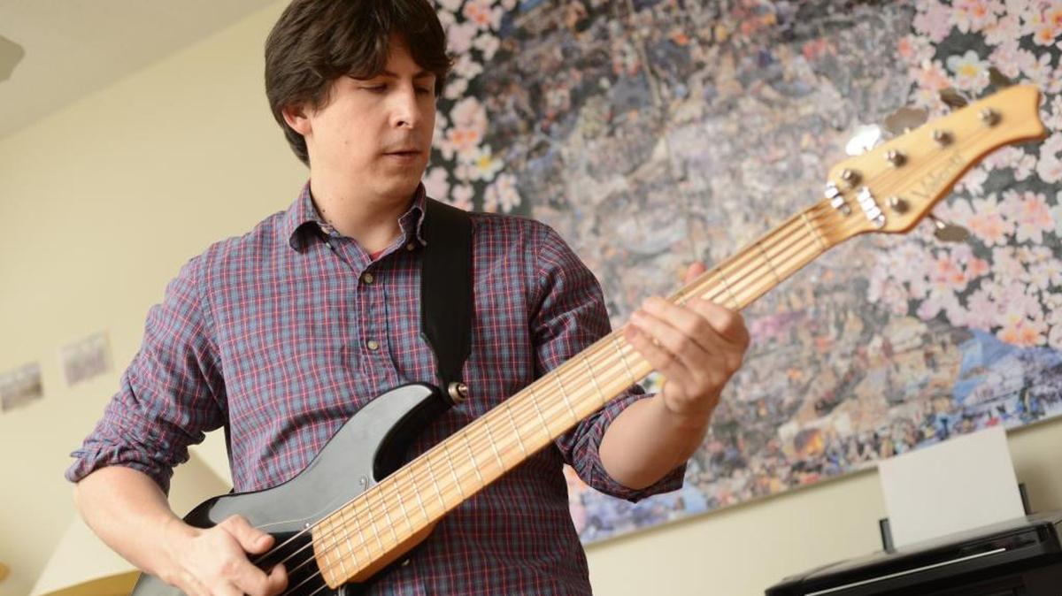 Chad Thompson warms up on his stand-up bass. Thompson works as a bass player at Legends in Concert.