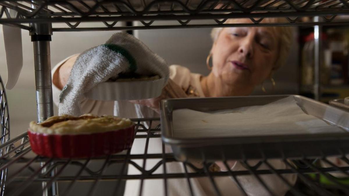 Barbara Whitley, owner of Crady’s in Conway, sets freshly baked quiches on a cooling rack in December.