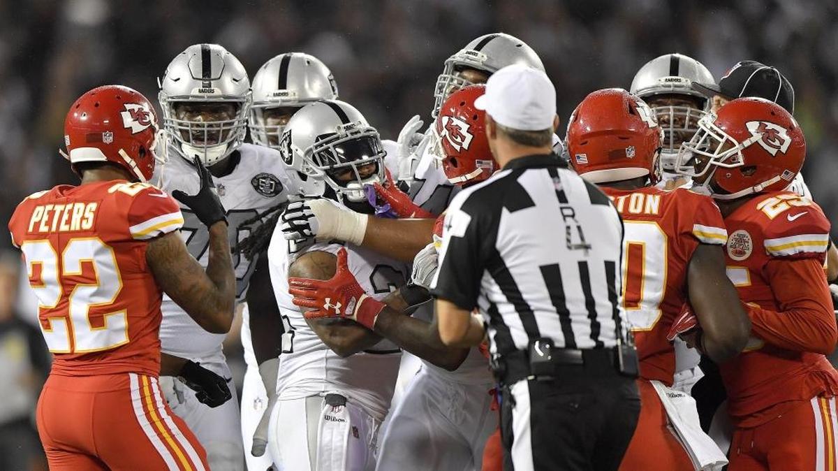 Oakland Raiders running back Marshawn Lynch, middle, is penalized for shoving an official during a scuffle with the Kansas City Chiefs on Thursday night.