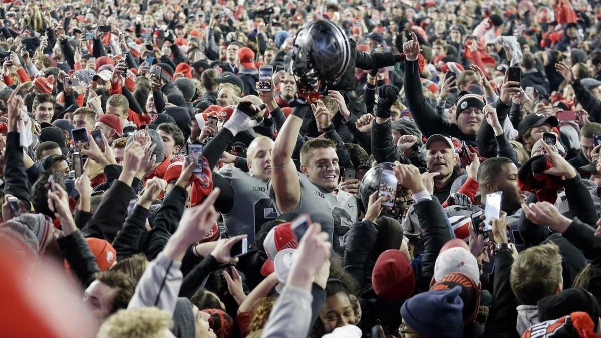 Ohio State Buckeyes defensive end Sam Hubbard (6) walks off as fans rush the field following a 39-38 win against Penn State on Saturday.