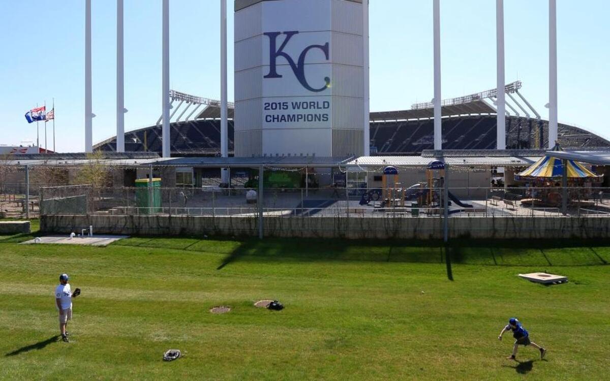 Jason, left, and Joshua Neland play catch behind the scoreboard at Kauffman Stadium before a Major League Baseball opening day game between the Kansas City Royals and the New York Mets on Sunday.