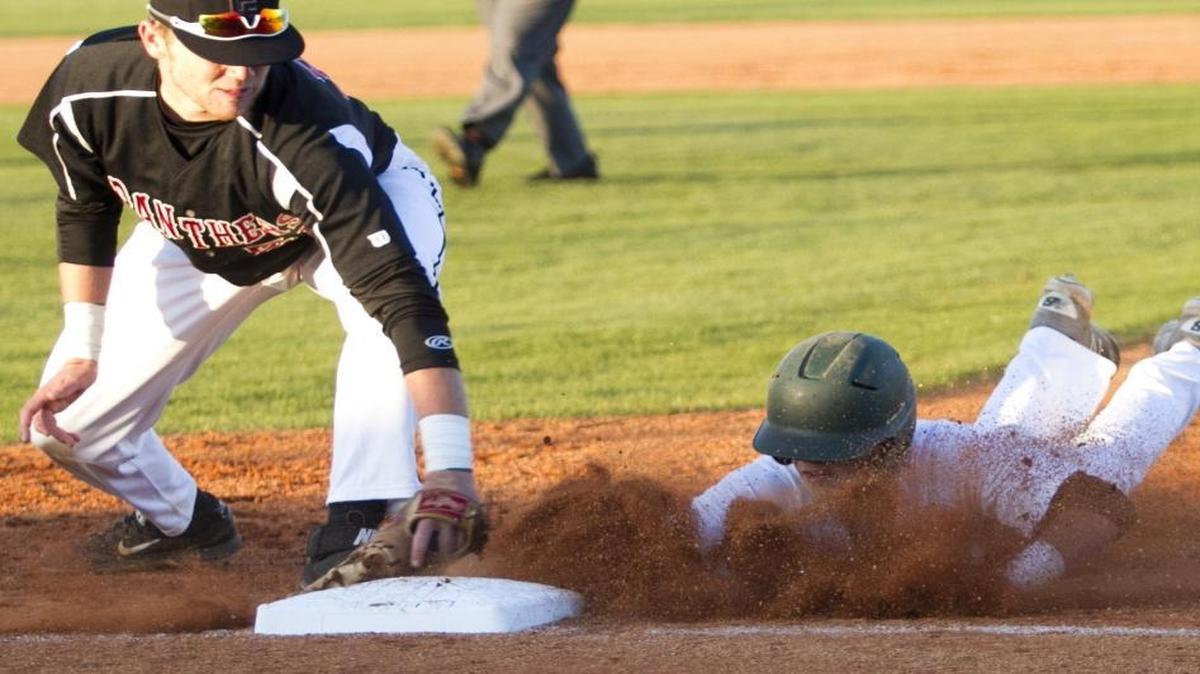 Conway’s Zack Lee dives back to first, avoiding a tag attempt by Carolina Forest’s Jared Lembcke during a game earlier this season.