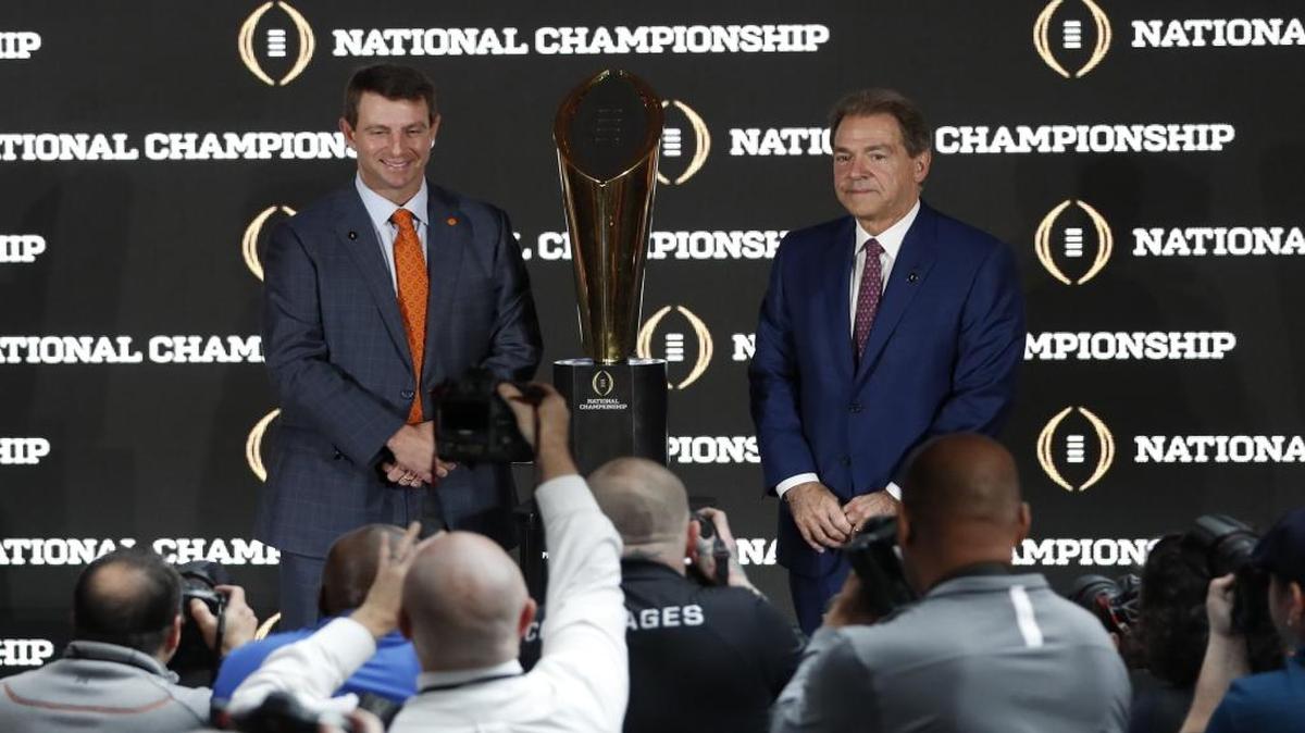 Clemson head coach Dabo Swinney and Alabama head coach Nick Saban pose with the championship trophy during a news conference Sunday.