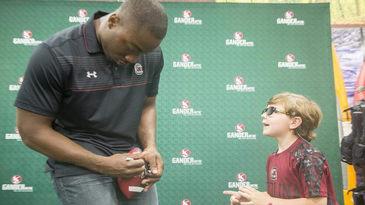 
Braxton Richardson, 5 years old of Myrtle Beach, is such a fan of Marcus Lattimore that he named his puppy “Marcus.” Richardson and other fans waited in line for up to an hour Saturday to get Lattimore’s autograph at the Grand Opening of Gander Mountain in Carolina Forest.
