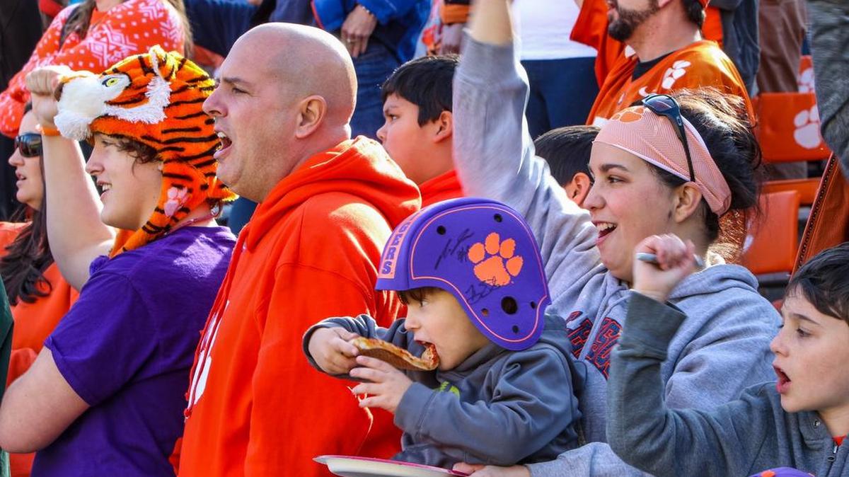 Jonathan Miller, 4, and his family enjoy the pizza party put on by Clemson coach Dabo Swinney at Memorial Stadium on Sunday. Each person that came received a free piece of pizza and Swinney and the team came out to listen to the College Football Playoff pairings announced on ESPN.