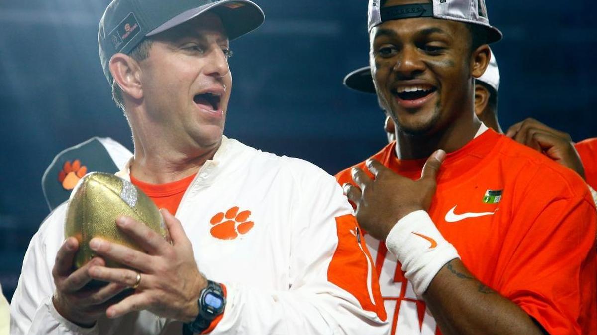 Clemson head coach Dabo Swinney holds the trophy as Clemson quarterback Deshaun Watson looks on after the Tigers defeated Ohio State 31-0 in the Fiesta Bowl.