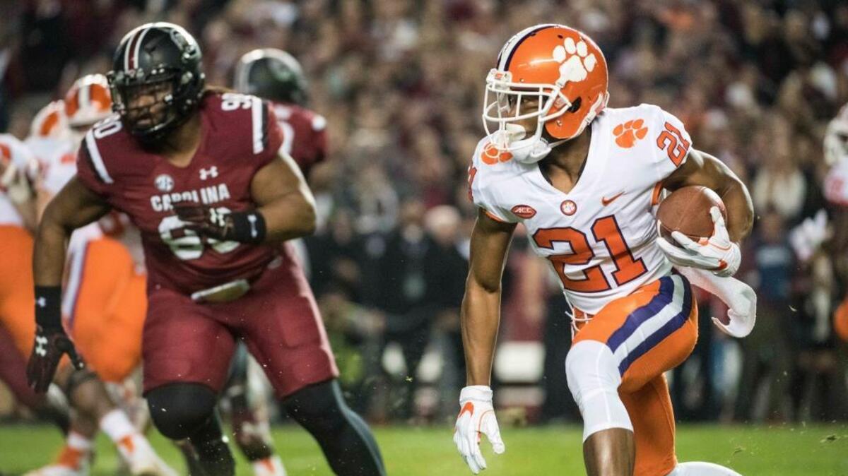 Clemson running back Darien Rencher (21) carries the ball against South Carolina defensive lineman Taylor Stallworth (90) during the first half Saturday.