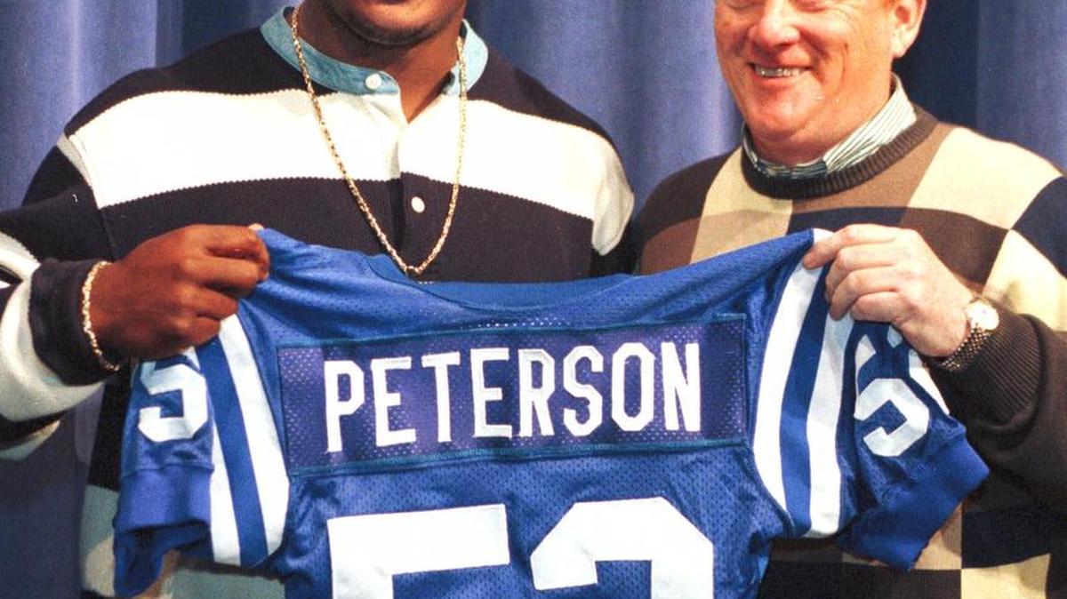 Indianapolis Colts second round draft pick Mike Peterson, a linebacker from the University of Florida, is given his team jersey by Colts president Bill Polian at the team headquarters in Indianapolis Sunday, April 18, 1999. (AP Photo/Michael Conroy)