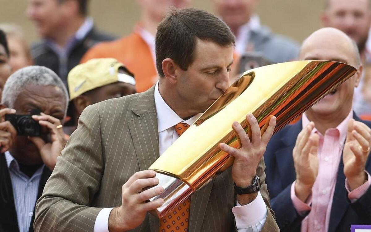 Clemson head coach Dabo Swinney kisses the CFP National Championship Trophy during a celebration at Memorial Stadium in January.