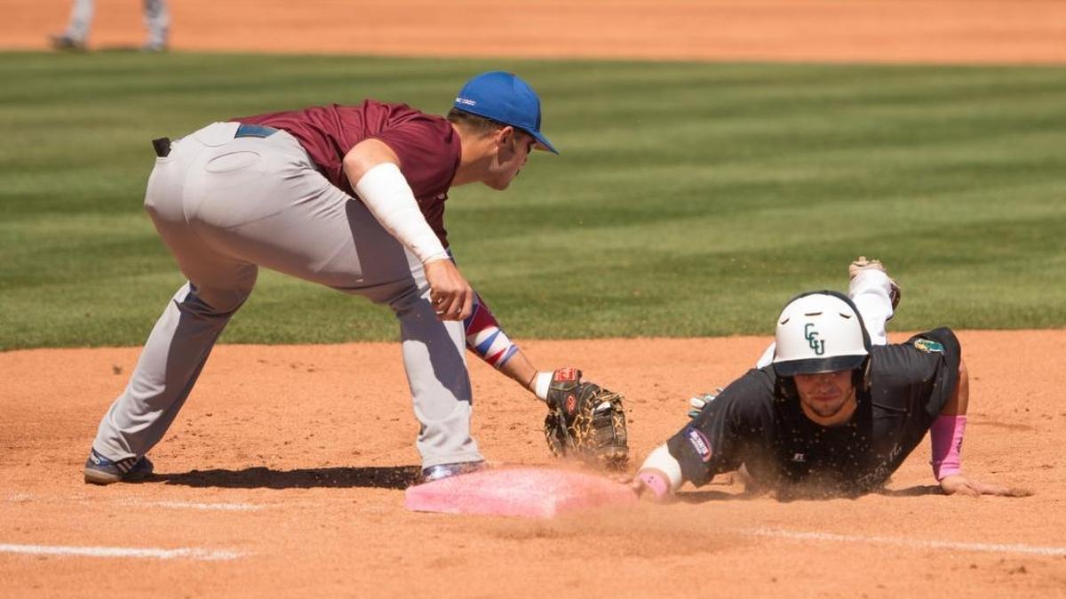 Coastal Carolina’s Michael Paez (right) dives safely back to first base as Presbyterian’s Peter Johnson goes for the tag.