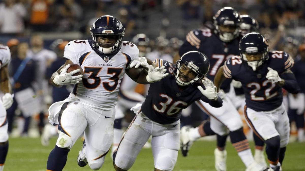 Denver Broncos running back and former Coastal Carolina standout De'Angelo Henderson (33) eludes several Chicago tacklers en route to scoring a touchdown in his NFL preseason debut.