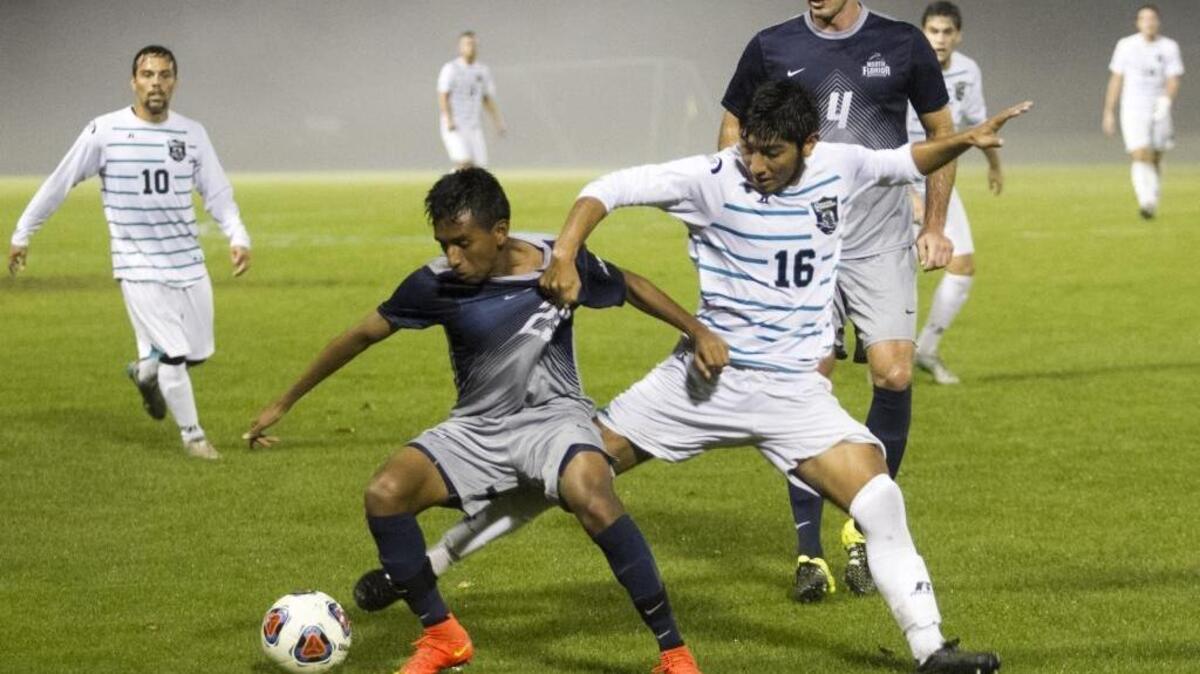 Coastal Carolina’s Martin Melchor attempts to block the path of North Florida’s Ivan Castro during Thursday night’s NCAA tournament first round game.