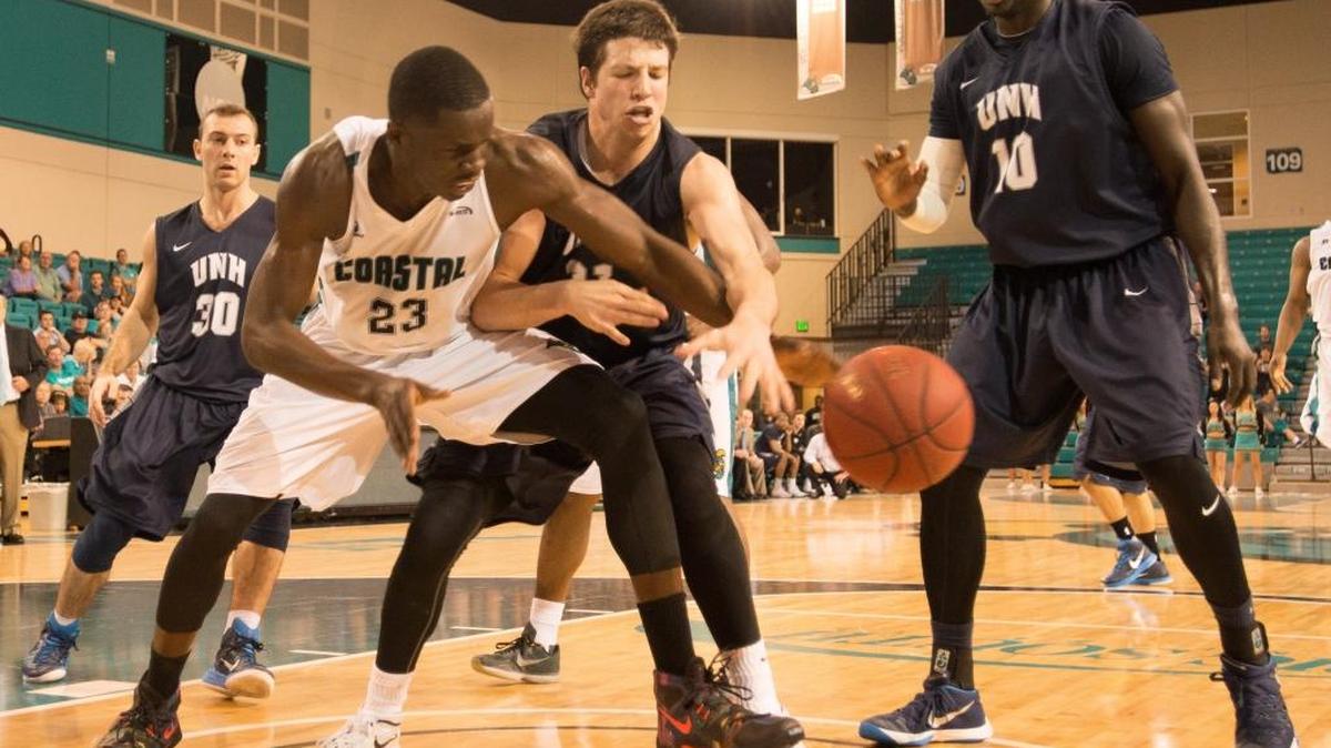 Coastal Carolina’s Badou Diagne (23) hauls in a rebound over New Hampshire’s Tanner Leissner during Saturday’s game.