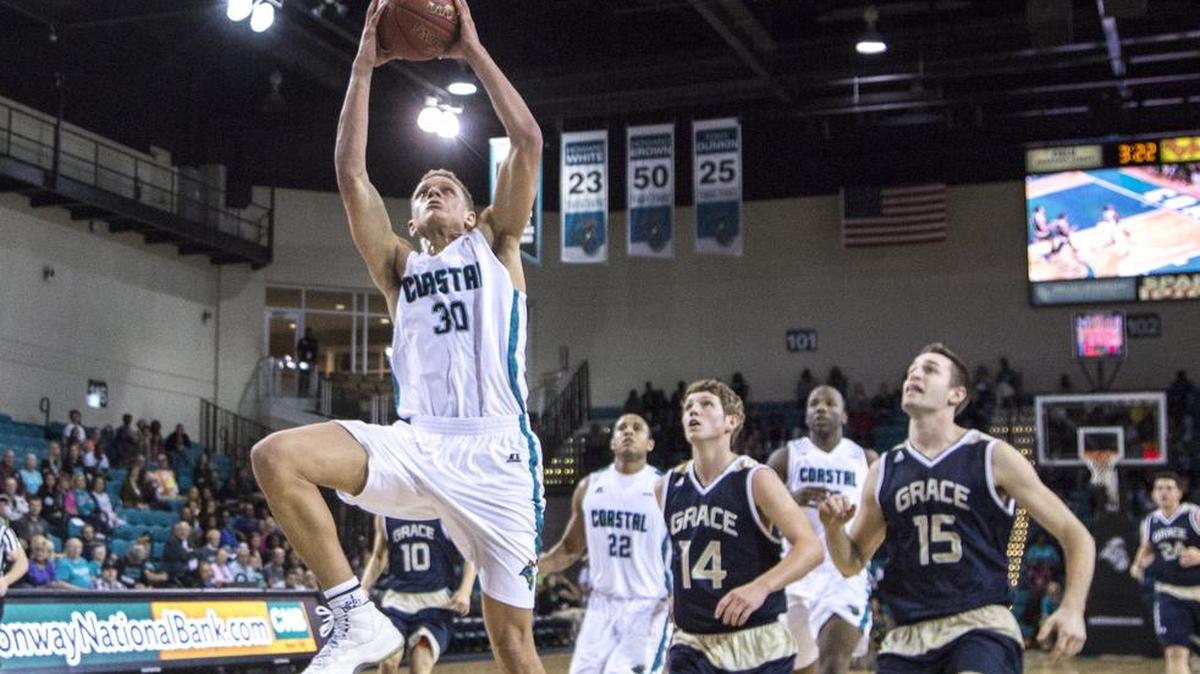 Coastal's Colton Ray-St Cyr jumps for the dunk against Grace Bible College.