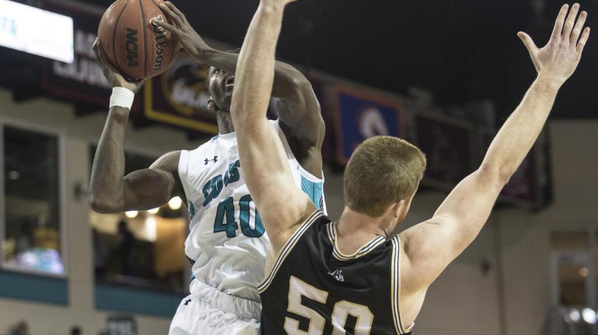 Coastal’s Zac Cuthbertson shoots over Wofford 6-11 center Matthew Pegram during the Chanticleers’ 87-81 loss Wednesday night at the HTC Center in CCU’s first home game against a Division I opponent of the 2017-18 season.