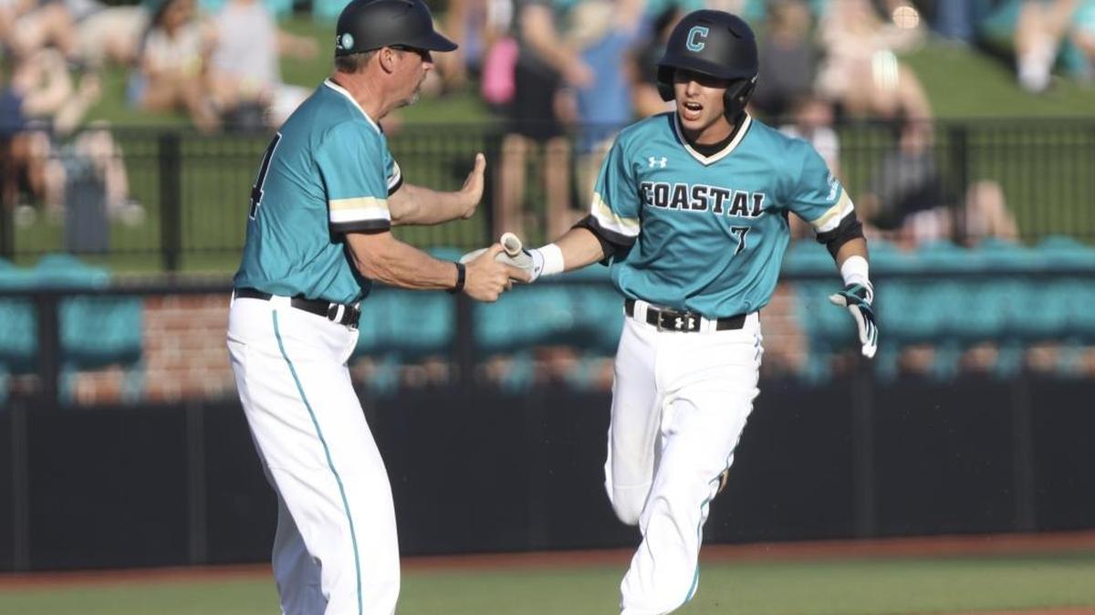 Coach Gary Gilmore congratulates Coastal Carolina shortstop Keaton Weisz on his way to scoring on a Kevin Woodall Jr. home run in CCU’s season-opening 17-2 win over Virginia Tech on Friday.