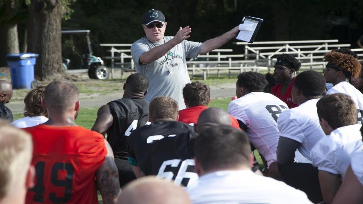 Coastal Carolina coach Joe Moglia addresses his team during the first day of practice.